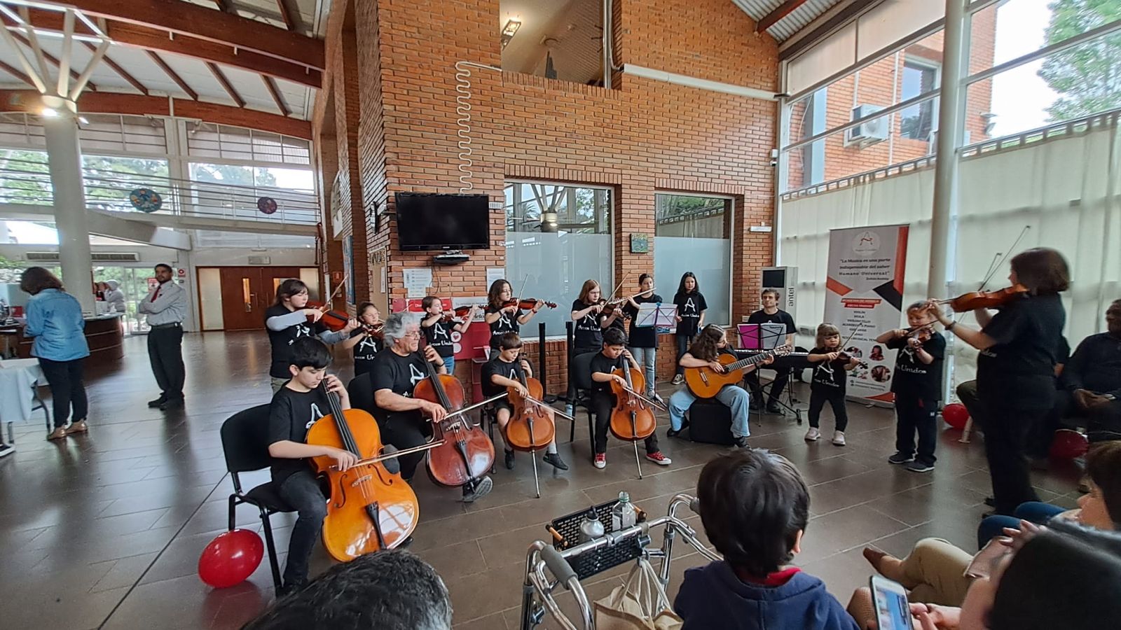 Orquesta infantil de Arcos Unidos tocando en el hall del centro cultural